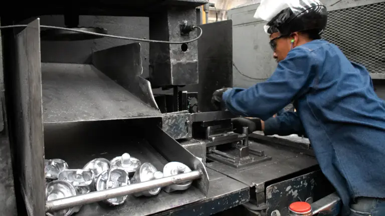 Industrial worker operating machinery in a metal processing facility
