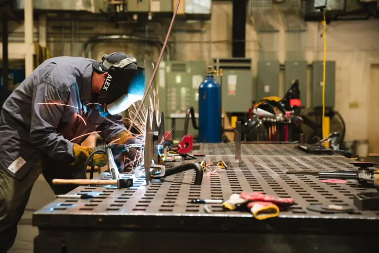 Steelworker forging and shaping metal in a fabrication workshop