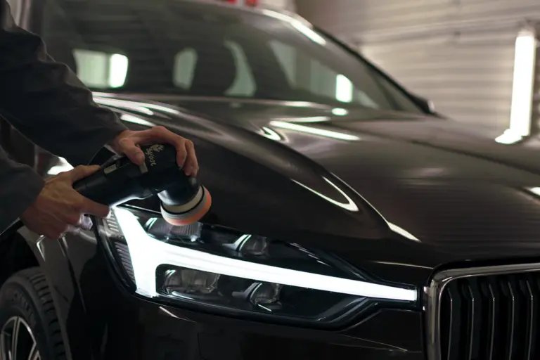 Professional detailer polishing a vehicle
