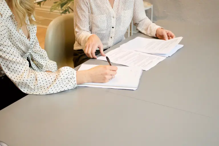 Person signing legal documents during a consultation