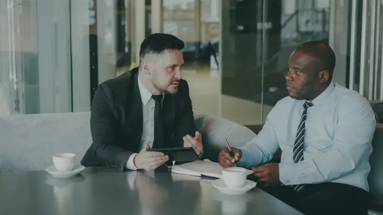 Two people reviewing and signing paperwork during a consultation