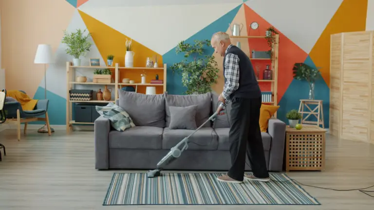 Person vacuuming carpet in a home