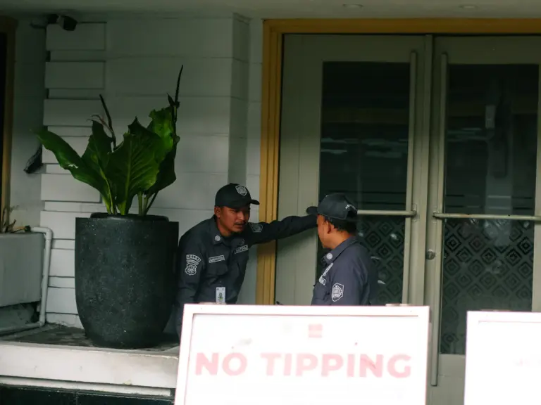 Two security guards discussing site security in a building lobby
