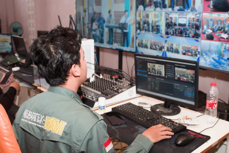 Uniformed security professional monitoring video equipment